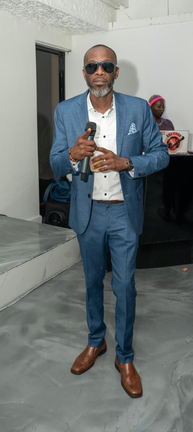SURVIVORSOUNDS hosting an event in a tailored blue suit